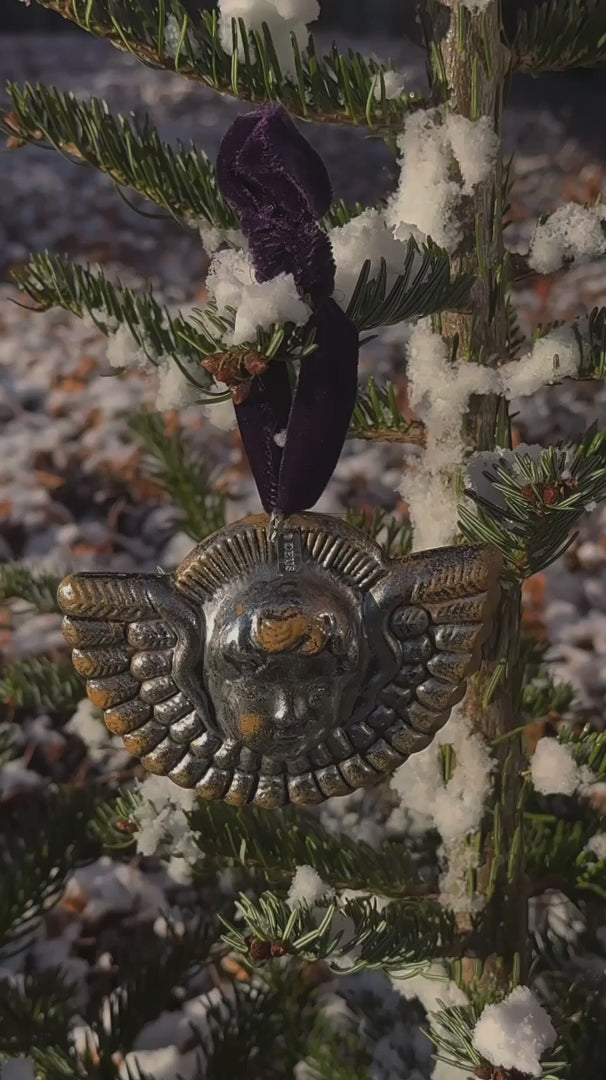 Sølvfarvet englehoved i metal